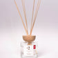 Reed diffuser with wooden sticks in a clear container on a white background